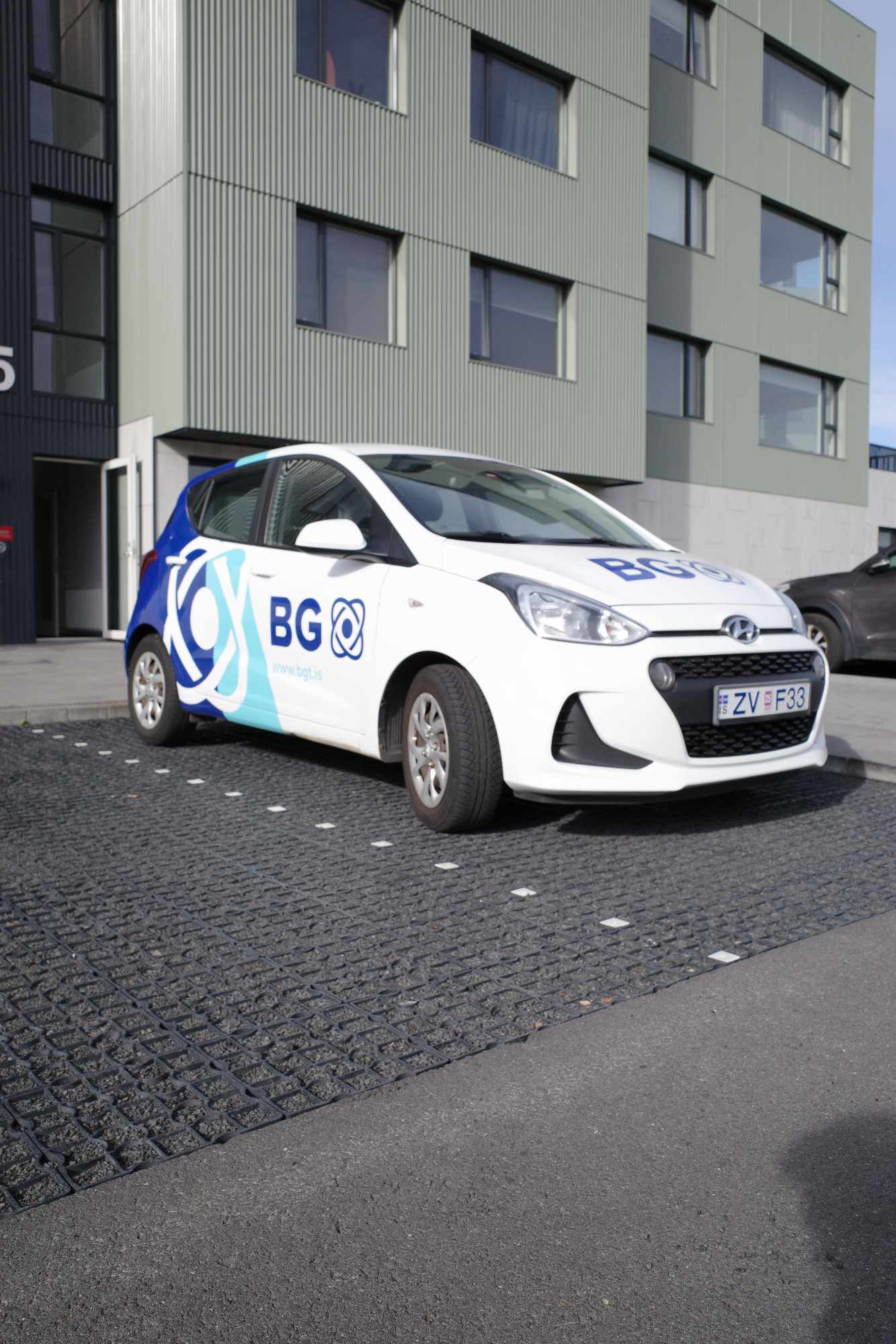 Starfsmaður BG Sameignaþrif þrífur inngang og glerhurð í sameign